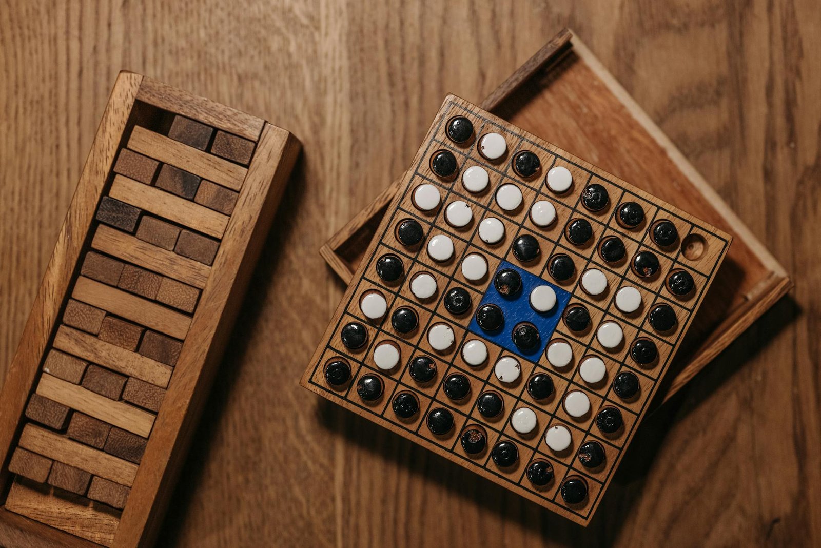 Top view of a classic wooden board game with black and white pieces on a wooden table.